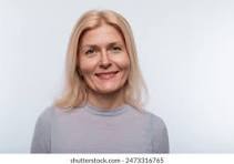 Woman with blonde hair wearing a gray sweater against a white background