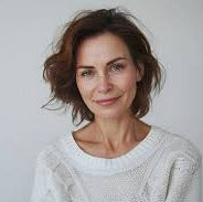Woman wearing a white sweater against a plain background